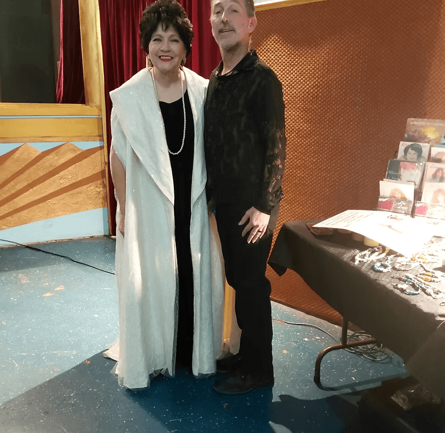 With Miss Lisa in a white gown beside the merch table